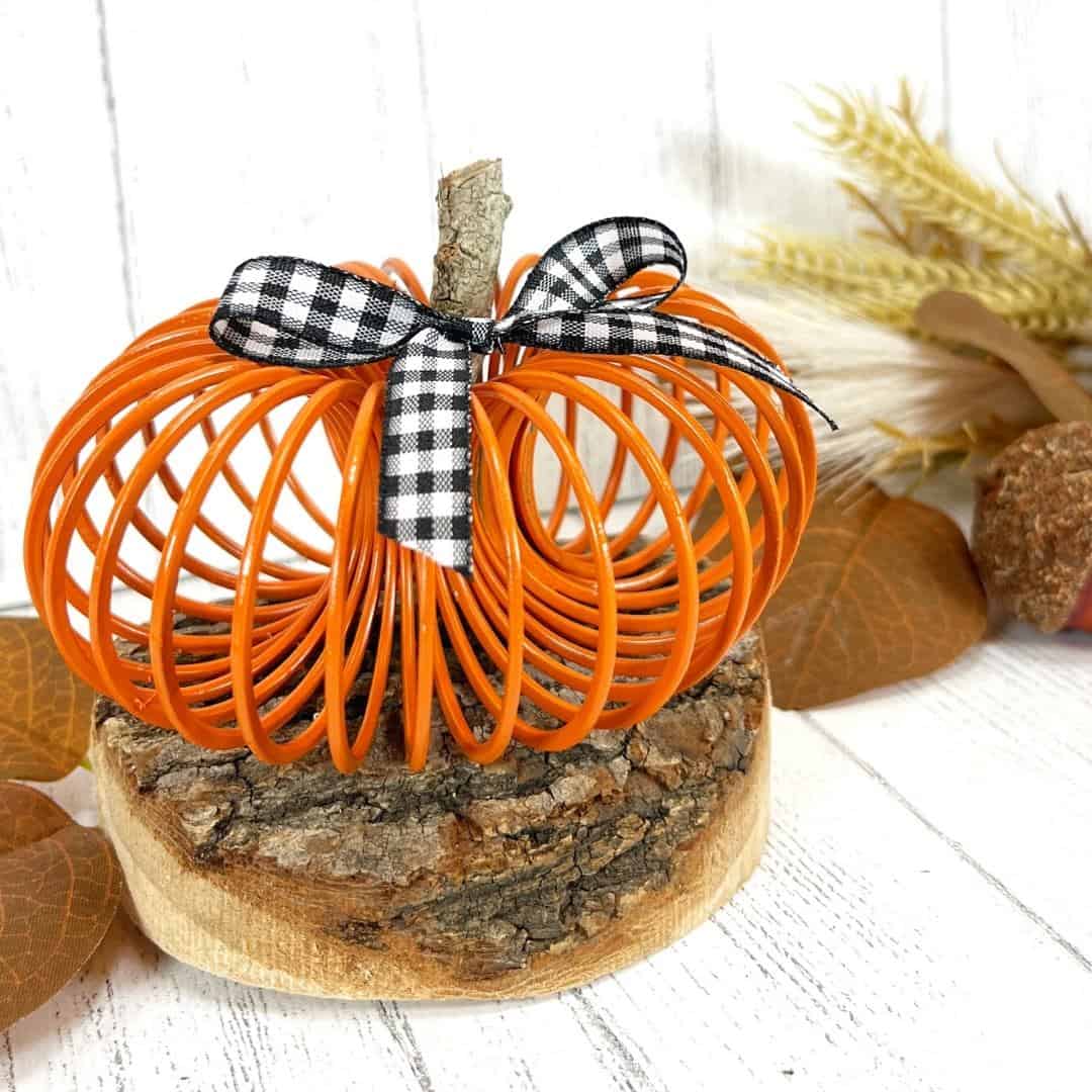 Easy Slinky Pumpkin Craft DIY, a simple Fall Halloween  décor idea for turning a spring toy into a pumpkin. Dollar store materials.