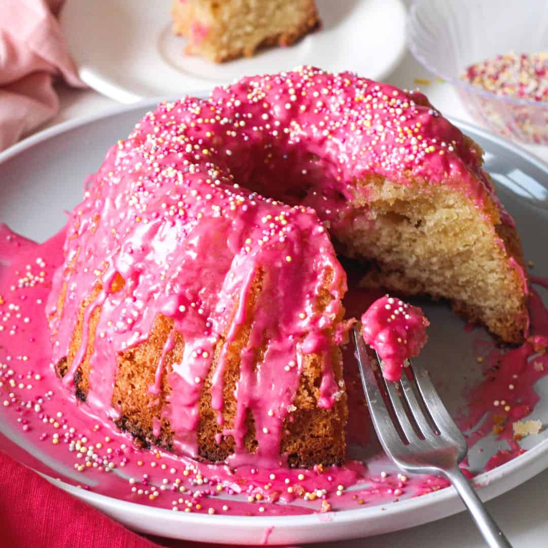 Easy Lemon Bundt Cake with Pink Glaze, a simple dessert recipe made with cake mix and pudding.Perfect for Birthdays and Mothers Day. 